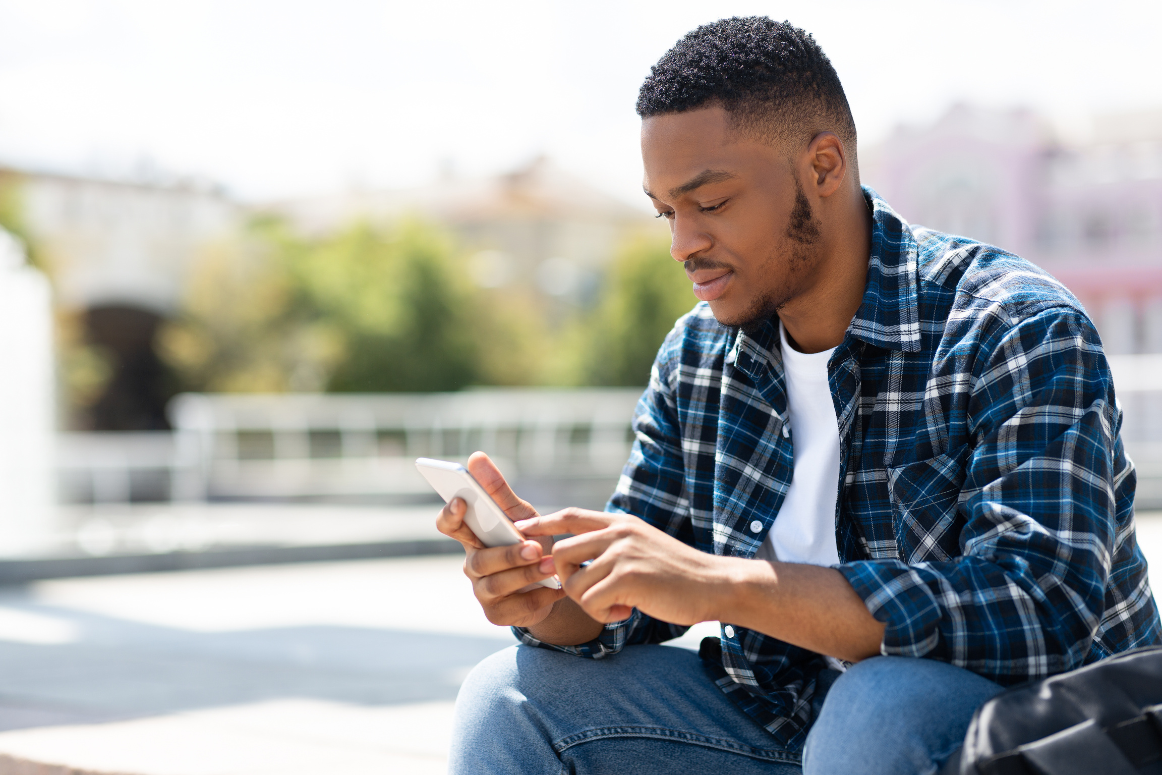 Portrait of black person texting sms on his smart phone